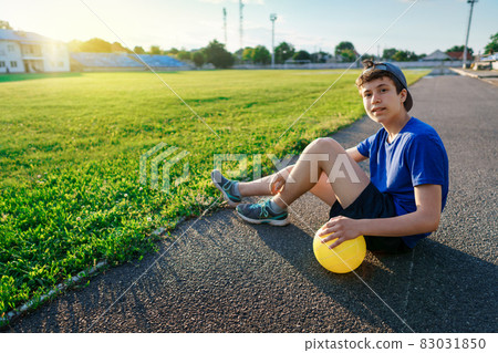 concept of sports and health - portrait of a teen boy posing at a stadium track, a soccer field with green grass concept of sports and health - portrait of a teen boy posing at a stadium track, a soccer field with green grass 83031850