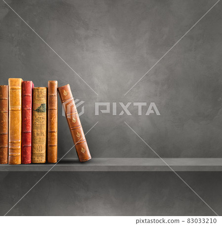 Row of old books on grey shelf. Square background 83033210