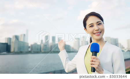 Female announcer standing in front of the city 83033644