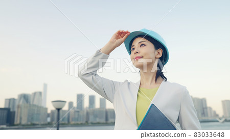 一位戴著頭盔、看著城市的女設計師和建築師 83033648