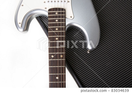 Silver electric guitar on guitar amplifier isolated on white background. Silver electric guitar on guitar amplifier isolated on white background. 83034639