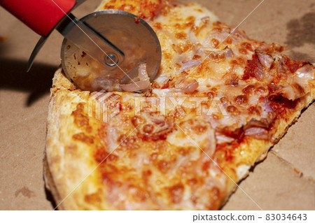 Leftovers of pizza in a takeaway box with pizza knife. Leftovers of pizza in a takeaway box with pizza knife. 83034643