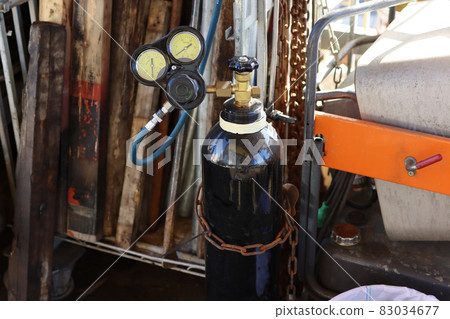 Image of a black oxygen cylinder with a regulator in the factory Image of a black oxygen cylinder with a regulator in the factory 83034677