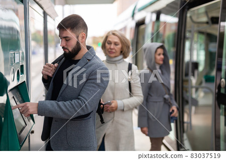 Man using ticket vending machine Man using ticket vending machine 83037519