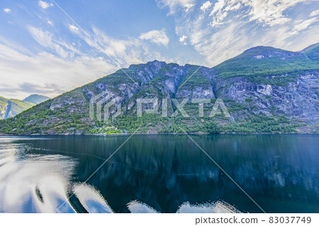 Impression from cruise ship on the way through Geiranger fjord in Norway at sunrise in summer 83037749
