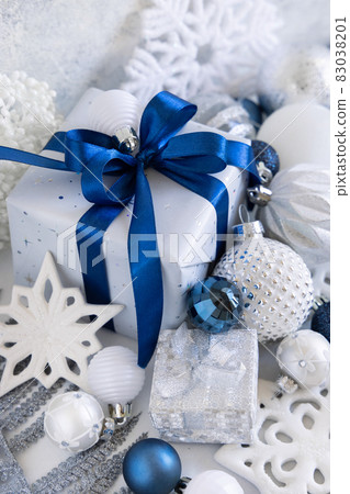 Christmas present with blue bow and silver decorations closeup Christmas present with blue bow and silver decorations closeup 83038201