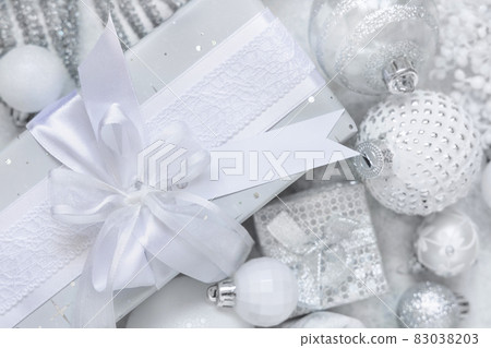 Christmas present with blank gift tag and white decorations, Mockup 83038203