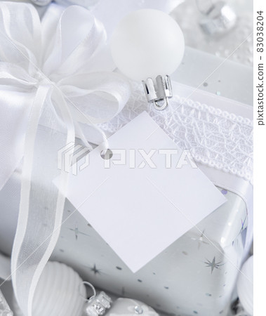 Christmas present with blank gift tag and white decorations, Mockup Christmas present with blank gift tag and white decorations, Mockup 83038204