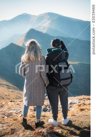 Travelers couple look at the mountains 83039466