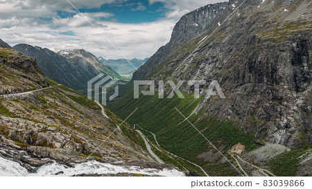 Trollstigen, Andalsnes, Norway. Stigfossen Waterfall Near Serpentine Mountain Road Trollstigen. Famous Norwegian Landmark And Popular Destination. Norwegian County Road 63 In Summer Day. 4K 83039866