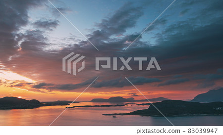 Alesund, Norway. Amazing Natural Bright Dramatic Sky In Warm Colours Above Alesund Valderoya And Islands In Sunset Time. Colorful Sky Background. Beauty In Norwegian Nature. 4K Alesund, Norway. Amazing Natural Bright Dramatic Sky In Warm Colours Above Alesund Valderoya And Islands In Sunset Time. Colorful Sky Background. Beauty In Norwegian Nature. 4K 83039947