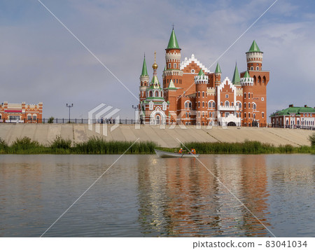 A pond with a pleasure boat and an embankment with buildings in Yoshkar-Ola, Russia 83041034