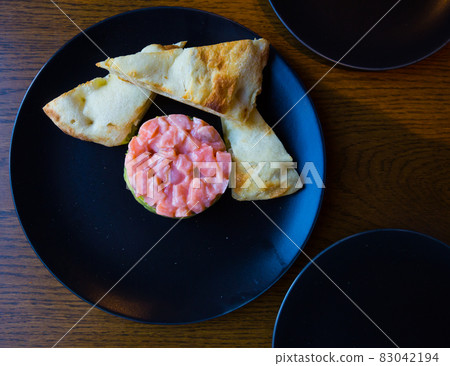Top view of salmon tartare with guacamole and toasts 83042194