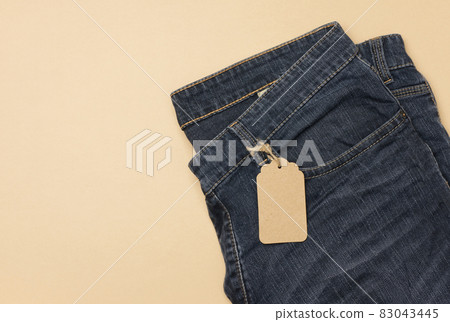 blank cardboard rectangular tag tied to blue jeans. blank cardboard rectangular tag tied to blue jeans. 83043445