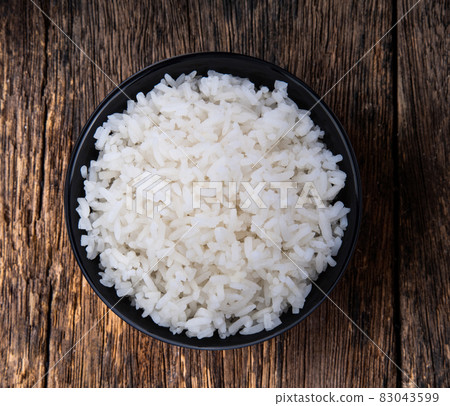 rice in black bowl on wood 83043599
