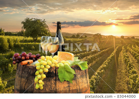 Sunset over Wachau valley with bottle of wine on barrel against golden vineyards in Austria Sunset over Wachau valley with bottle of wine on barrel against golden vineyards in Austria 83044000