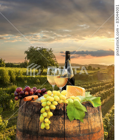 Colorful sunset over Wachau valley with bottle of wine on barrel against golden vineyards in Austria Colorful sunset over Wachau valley with bottle of wine on barrel against golden vineyards in Austria 83044001