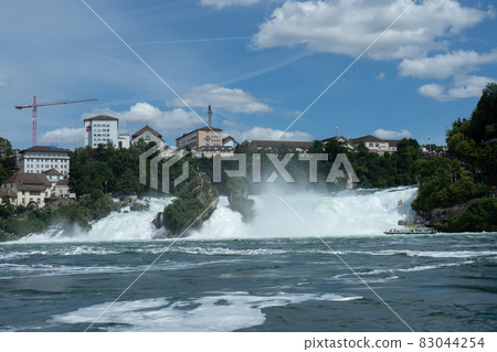 Rhine waterfalls in Southern Germany on a sunny afternoon at high water level 83044254