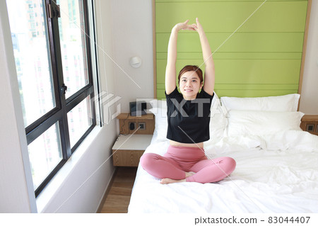 woman stretch her arm on bed 83044407