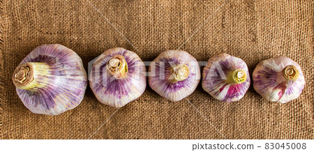 Fresh aromatic garlic on a wooden background. Fragrant spice for cooking. Fresh aromatic garlic on a wooden background. Fragrant spice for cooking. 83045008