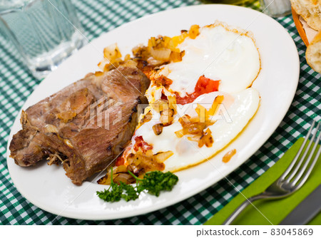 Image of dish of tasty cooked fried pork with fried eggs Image of dish of tasty cooked fried pork with fried eggs 83045869