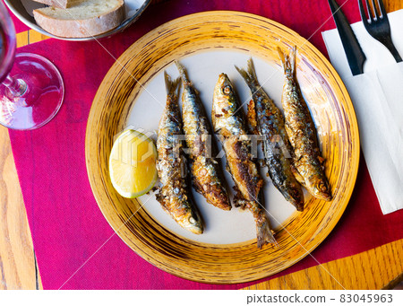 Fried sardines served with slice of lemon 83045963