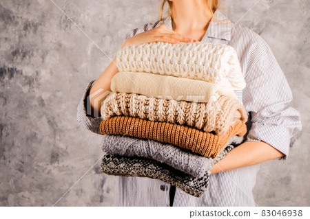 Minimalistic rustic composition with stacked vintage knitted easy chic oversized style sweaters, knitwear outfit. 83046938
