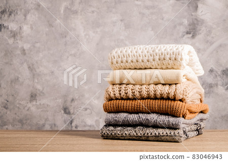 Minimalistic rustic composition with stacked vintage knitted easy chic oversized style sweaters, knitwear outfit. Minimalistic rustic composition with stacked vintage knitted easy chic oversized style sweaters, knitwear outfit. 83046943