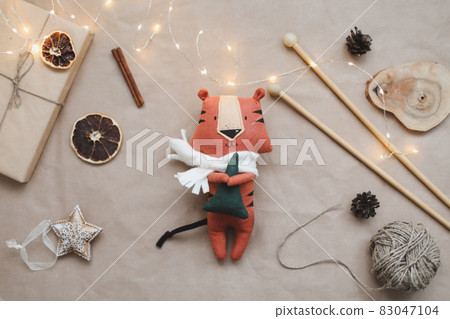 Christmas composition with a tiger toy, symbol of new 2022, a gift, fir tree branches and decorations. Christmas, winter, new year concept. Flat lay, top view 83047104