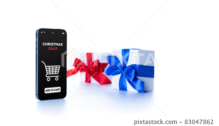 Online Christmas shopping. Internet shop application on digital smartphone screen with gift box red ribbon in online shopping composition. Winter Xmas holidays sales. 83047862