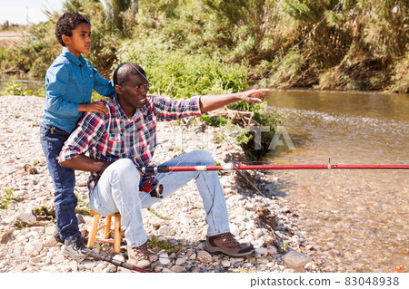 Man and boy fishing with rods Man and boy fishing with rods 83048938