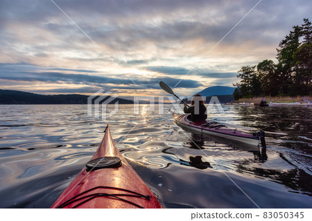 Adventurous Woman on Sea Kayak paddling in the Pacific Ocean. Adventurous Woman on Sea Kayak paddling in the Pacific Ocean. 83050345