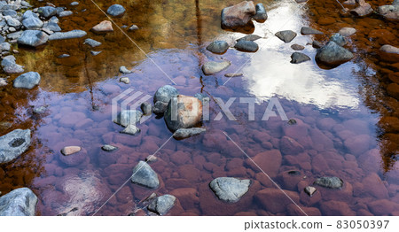 Water running down the river around rocks. Water running down the river around rocks. 83050397