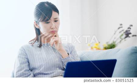 在沙發上使用筆記本電腦的女人 83051525