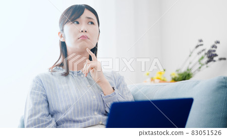 在沙發上使用筆記本電腦的女人 83051526