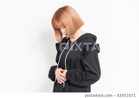 Young woman holding her stomach with her hands Young woman holding her stomach with her hands 83051871