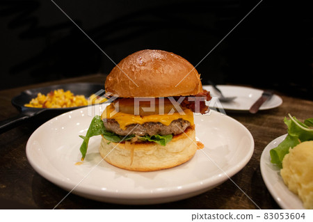 hawaiian burger on white plate on wooden table 83053604
