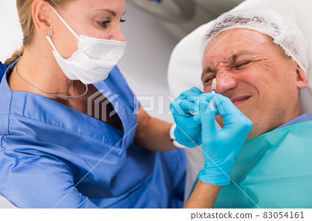 Female specialist is doing injection to client for anti-aging Female specialist is doing injection to client for anti-aging 83054161