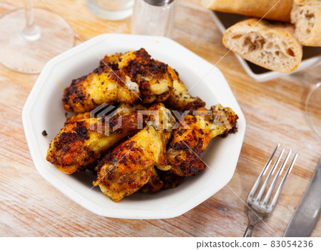 Fried chicken wings with golden crust served with on plate Fried chicken wings with golden crust served with on plate 83054236