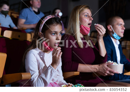 mother, her child sitting at film in auditorium during epidemic 83054352