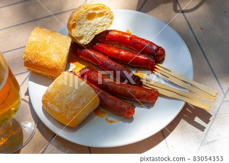Mildly spiced grilled mini sausages chistorra. Tapa from Basque Country cuisine 83054353