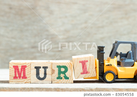 Toy forklift hold letter block i to complete word muri on wood background Toy forklift hold letter block i to complete word muri on wood background 83054558