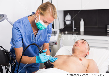 Female doctor is doing vacuum massage procedure for anti-fat to patient Female doctor is doing vacuum massage procedure for anti-fat to patient 83054576