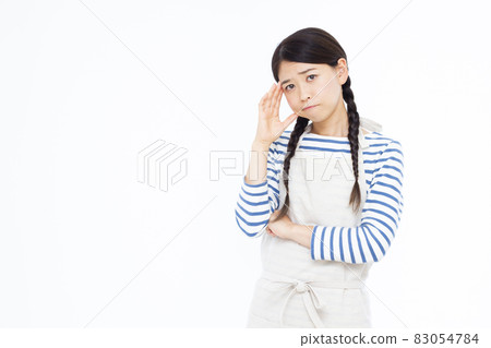 A woman in her thirties holding her head 83054784