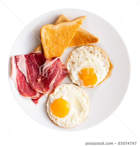 Fried eggs with slices of ham and wheat bread toasts 83054797