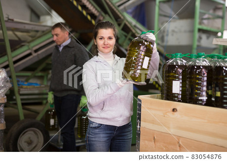 Woman with plastic bottle of olive oil Woman with plastic bottle of olive oil 83054876