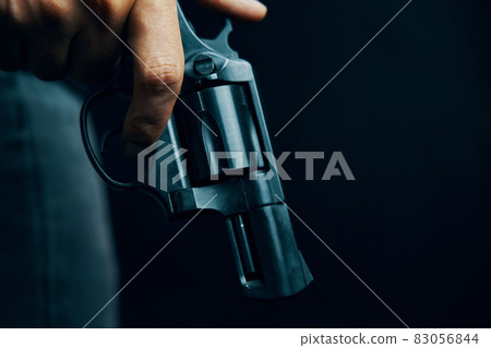Black revolver with drum in man's hand. 83056844