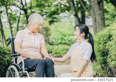 老年婦女和坐輪椅的女工作人員 老年婦女和坐輪椅的女工作人員 83057025