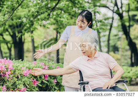 老年婦女和坐輪椅的女工作人員 老年婦女和坐輪椅的女工作人員 83057027
