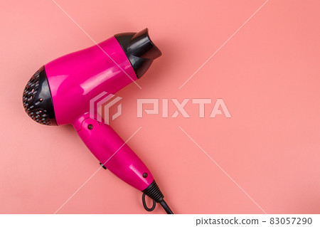 Pink hair dryer on a pastel pink background. Top view Pink hair dryer on a pastel pink background. Top view 83057290